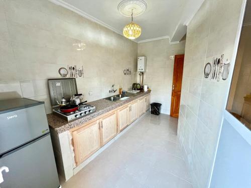 Una cocina con refrigerador y fregadero. en Mamoun allawii, en Asilah