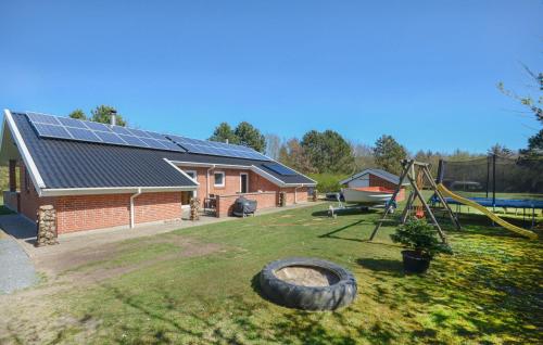 ein Haus mit Spielplatz und ein Haus mit Solarmodulen in der Unterkunft Ocean Front Home In Spøttrup With Sauna in Vadum