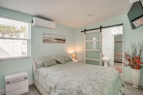 a bedroom with a white bed and a window at Walk to Ocean! Home with Large Yard in Ormond Beach in Ormond-by-the-Sea
