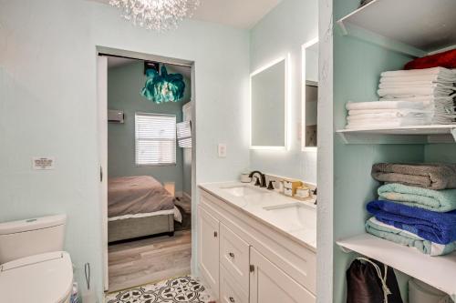 a bathroom with a sink and a toilet and a mirror at Walk to Ocean! Home with Large Yard in Ormond Beach in Ormond-by-the-Sea