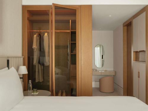 a bedroom with a closet with a bed and a mirror at Delano Dubai at Bluewaters in Dubai