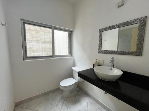 Confortable casa en Cozumel, cerca del mar #10 في كوزوميل: حمام مع حوض ومرحاض ومرآة