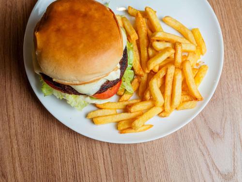 a white plate with a sandwich and french fries at ibis Lavras in Lavras