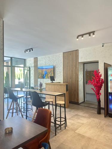a dining room with tables and chairs and windows at Prestige apartmani Zlatibor-Prestige Forest Resort in Zlatibor