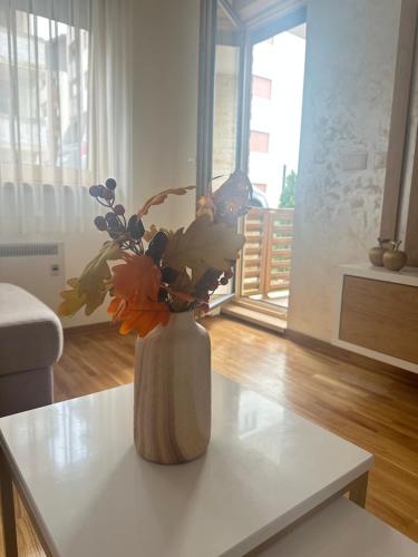 a vase with flowers on a table in a living room at Prestige apartmani Zlatibor-Prestige Forest Resort in Zlatibor