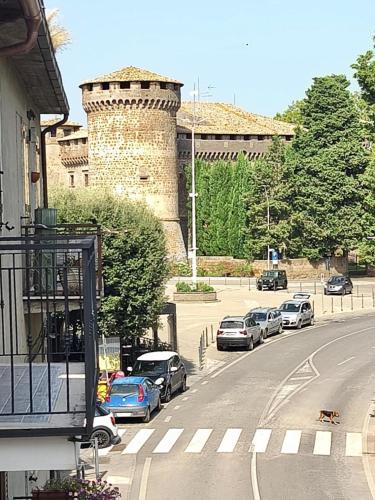 a street with cars parked in front of a castle at Dedè&Mimì Come a casa tua in Vasanello