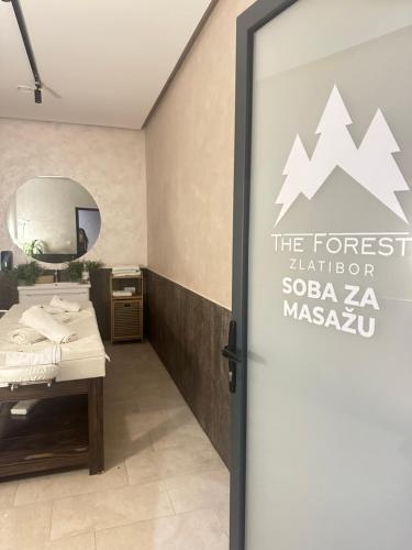 a bathroom with a mirror and a sign on the door at Prestige apartmani Zlatibor-Prestige Forest Resort in Zlatibor
