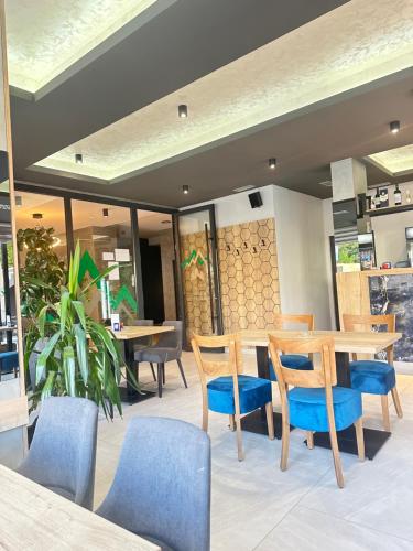 a dining room with tables and blue chairs at Prestige apartmani Zlatibor-Prestige Forest Resort in Zlatibor