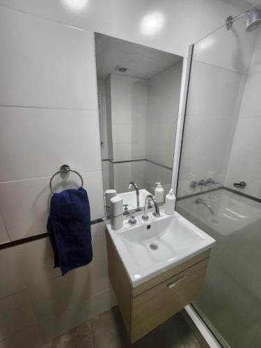 a bathroom with a sink and a shower with a mirror at Dpto Arroyito in Rosario