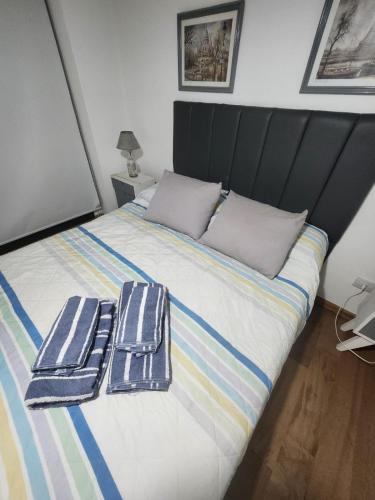 a bed with two towels sitting on top of it at Dpto Arroyito in Rosario
