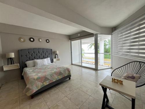 una camera da letto con un letto, un tavolo e una sedia di Estudio en Cozumel con vista al mar A1 a Cozumel