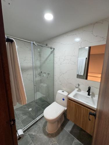a bathroom with a toilet and a shower and a sink at Hotel Colonial Santa Barbara in Tunja