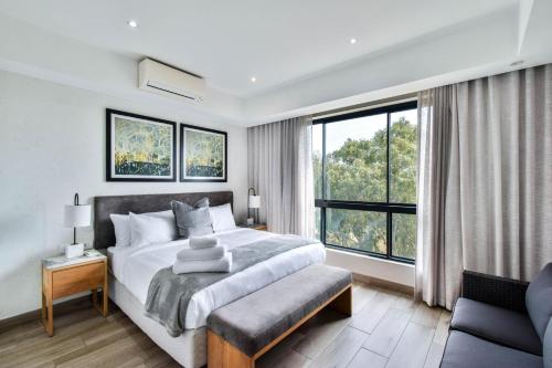 a bedroom with a bed and a large window at Menlyn apartment with ensuit Regency Hotel in Pretoria