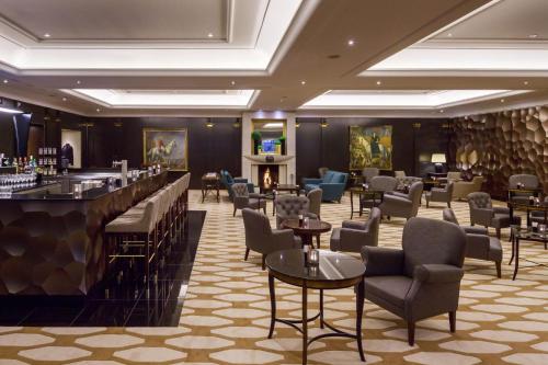 a hotel lobby with a bar and chairs at Hotel Bristol Berlin in Berlin