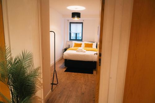a bedroom with a bed with yellow pillows at Stylish Luxury Two Bed Jewellery Quarter in Birmingham