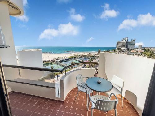 a balcony with a table and chairs and a view of the beach at Beachfront Sky Loft in Herzliya B