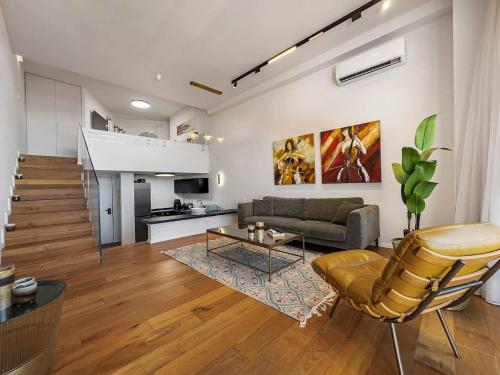 a living room with a couch and a table at Beachfront Sky Loft in Herzliya B