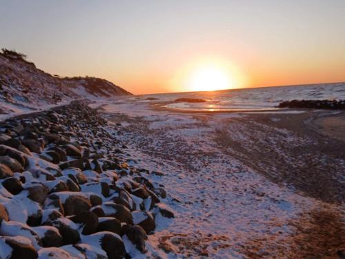 a group of rocks on the beach at sunset at 8 person holiday home in Tisvildeleje in Tisvildeleje