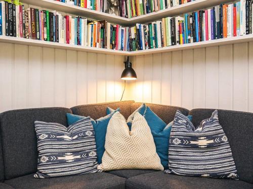 a couch with pillows on it with books at 8 person holiday home in Tisvildeleje in Tisvildeleje
