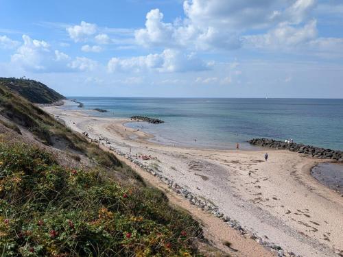 a beach with people on the sand and the ocean at 8 person holiday home in Tisvildeleje in Tisvildeleje