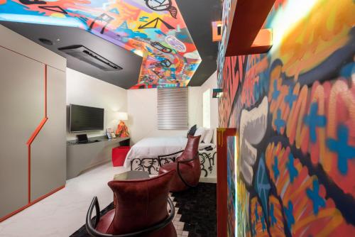 a room with a bed and a painting on the wall at Hotel The Designers Kondae in Seoul