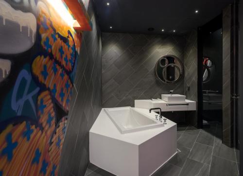 a bathroom with a sink and a mirror at Hotel The Designers Kondae in Seoul