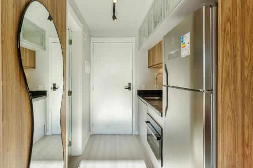 a kitchen with a stainless steel refrigerator and a hallway at Novíssimo - Skyline Parque Moinhos in Porto Alegre
