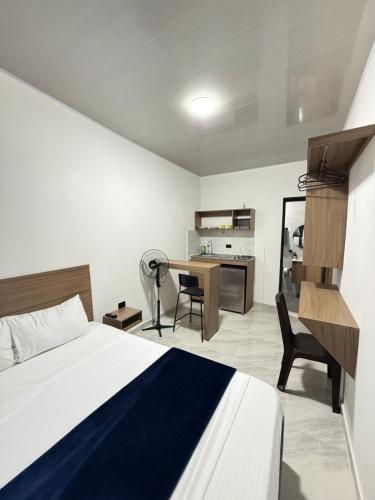 a bedroom with a bed and a desk with a chair at Coliving C33- Apartaestudios En Palmira Centro in Palmira