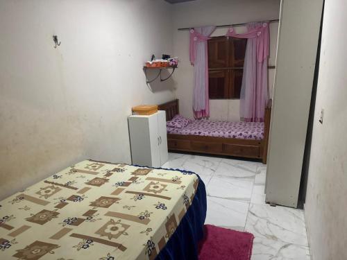 una piccola stanza con un letto e una finestra di casa paraíso a Marituba