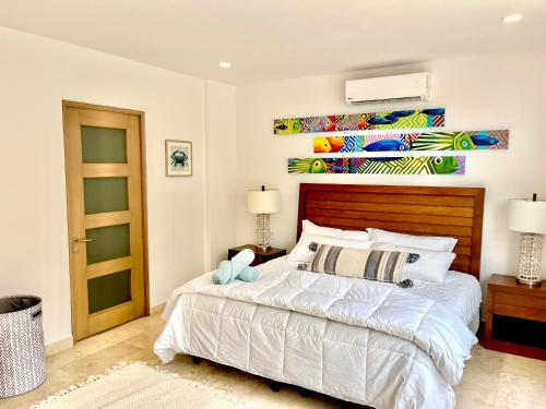 a bedroom with a large bed with a wooden headboard at Spacious Pool Side Condo - SJD in San José del Cabo