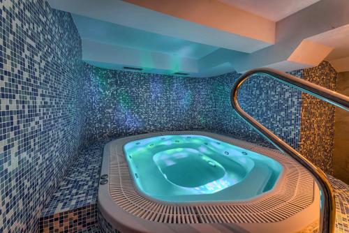 克魯斯克奇的住宿－Hotel Pod Wulkanem，浴室设有按摩浴缸,铺有马赛克瓷砖。