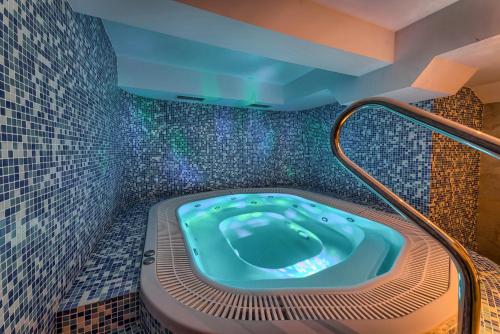 a jacuzzi tub in a bathroom with mosaic tiles at Hotel Pod Wulkanem in Kluszkowce