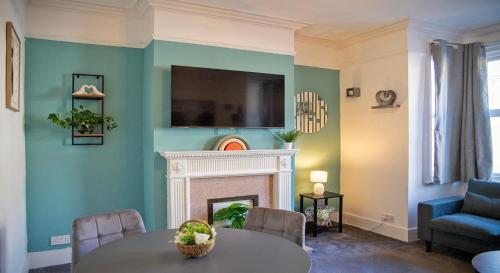 a living room with a table and a fireplace at The Channel View, 4 bedrooms, 4 beds, FREE parking, 3 minutes from the beach in Eastbourne