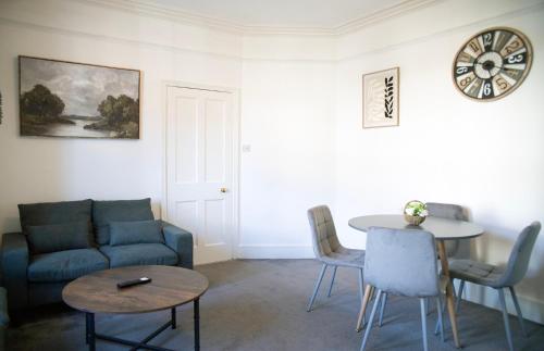 a living room with a couch and a table at The Channel View, 4 bedrooms, 4 beds, FREE parking, 3 minutes from the beach in Eastbourne