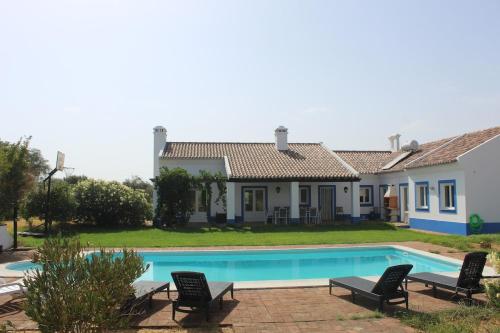 a villa with a swimming pool in front of a house at Quinta do Sobreiro in Reguengos de Monsaraz