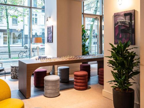 a waiting room with a table and stools at TRIBE Düsseldorf in Düsseldorf