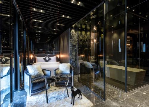 a bedroom with a bed and a black cat standing next to a window at Hotel The Designers Kondae in Seoul