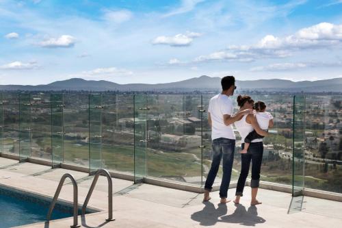 a couple standing on the edge of a building looking at the city at Holiday Inn Express & Suites Puebla Angelopolis by IHG in Puebla