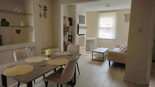 a dining room and living room with a table and chairs at 2 Bed Cottage Retreat Windsor, Slough and Legoland in Slough
