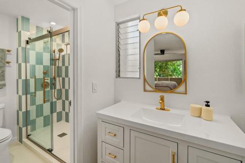 a white bathroom with a sink and a mirror at Modern Princeville 1 bedroom, AC, King Bed, Hanalei in Princeville