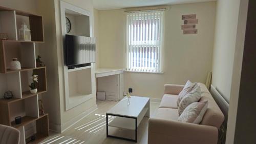 a living room with a couch and a coffee table at 2 Bed Cottage Retreat Windsor, Slough and Legoland in Slough