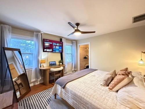 a bedroom with a bed with a ceiling fan and a desk at Vibing Hudson Retreat Pet-Friendly w Hot Tub in Hudson