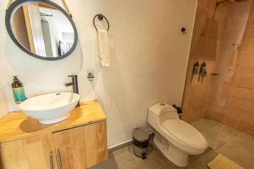 a bathroom with a sink and a toilet and a mirror at La Martina Boutique Hotel in Medellín