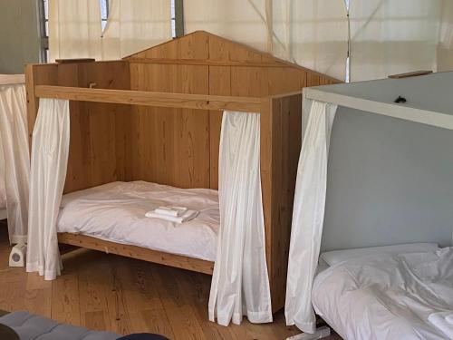 a bunk bed in a room with two beds at 'Yamaneko Hotel 'Saunas, Serenity & Feline Friends in Miyoshi