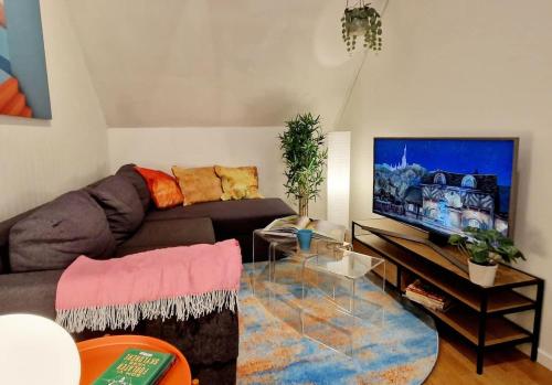 Una sala de estar con un sofá y un televisor de pantalla plana. en King bed Great location Top floor, en Bergen