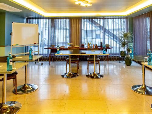 a conference room with tables and a whiteboard in it at MUZE Hotel Dusseldorf - Handwritten Collection in Düsseldorf