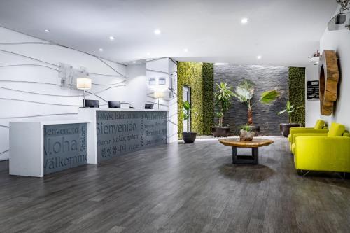 a lobby with a yellow chair and a table at Holiday Inn Express & Suites Puebla Angelopolis by IHG in Puebla