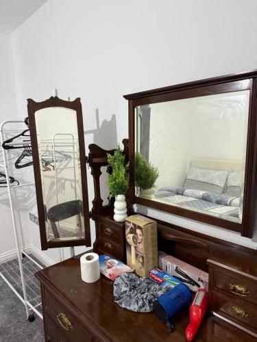 a wooden dresser with a mirror and a dresser with a bed in it at Mary Apartment in London