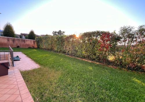 a backyard with a lawn with a fence and a garden at L' Incanto in Rovato