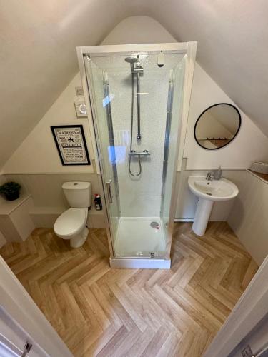 a bathroom with a shower and a toilet and a sink at Sunset Cottage in Hunstanton